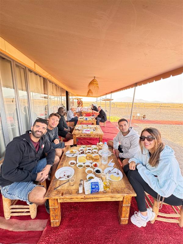 Coppia che fa colazione sotto la tenda berbera dopo il volo in mongolfiera
