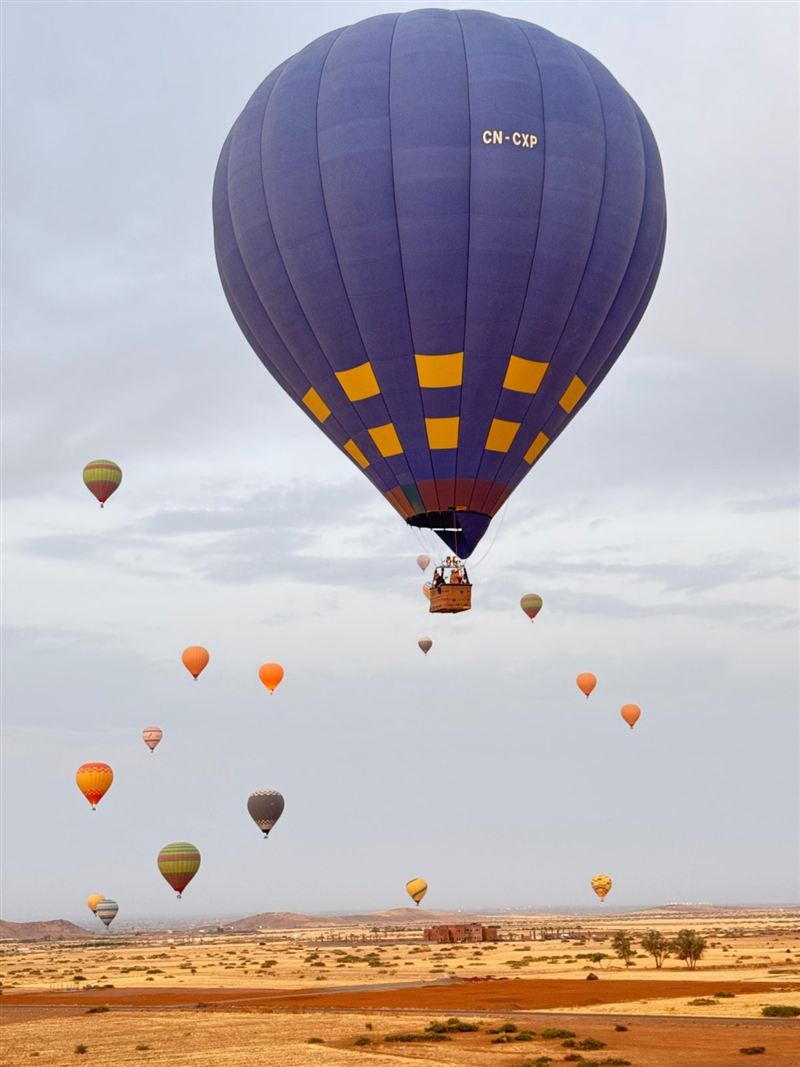 Mongolfiera blu in volo con tante mongolfiere sullo sfondo
