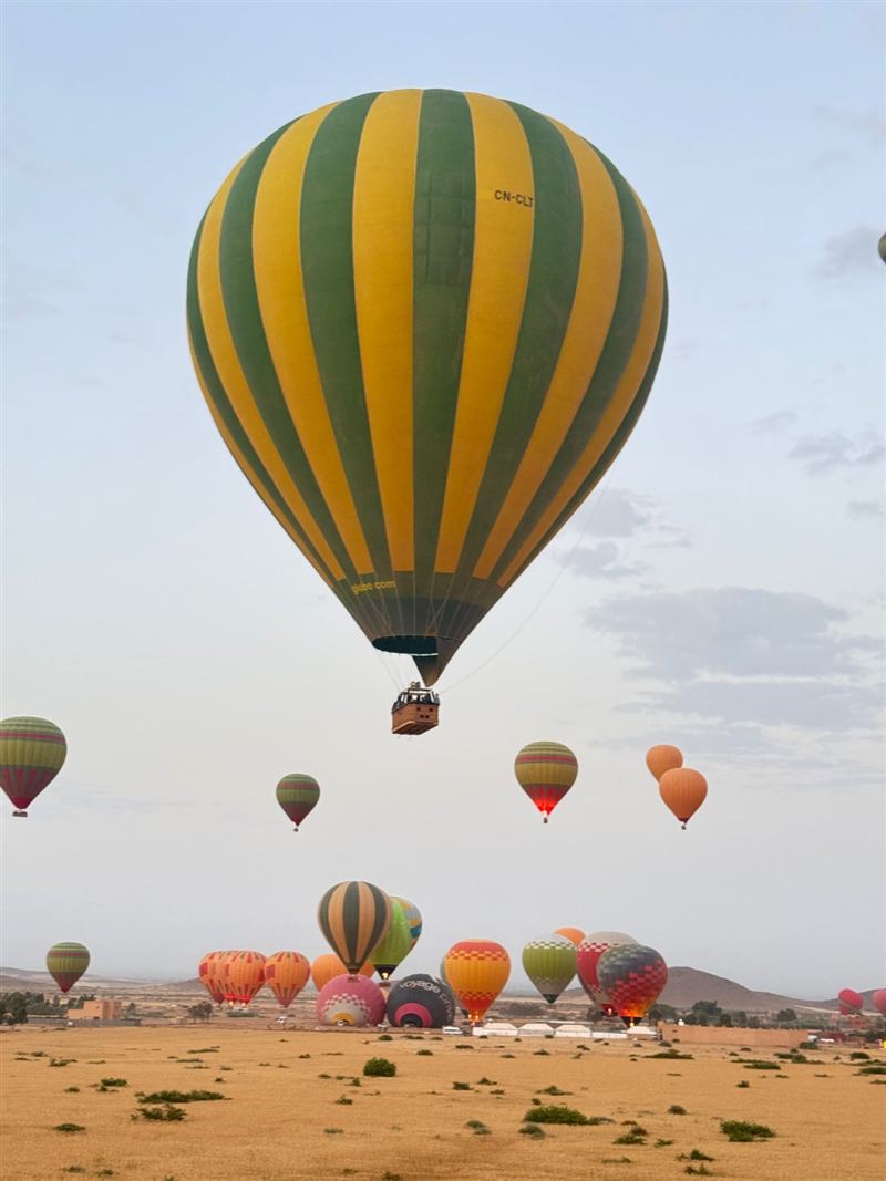 Mongolfiera a strisce verdi e gialle che decolla
