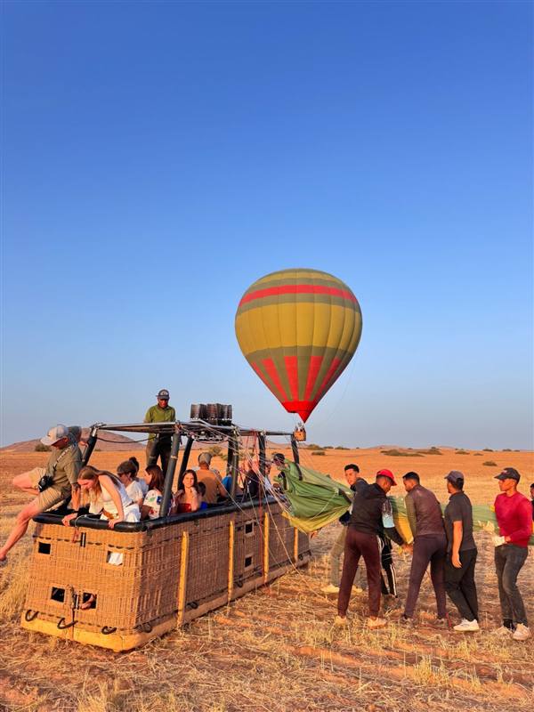Grande cesta di un volo condiviso in mongolfiera con i passeggeri a bordo prima del decollo a Marrakech