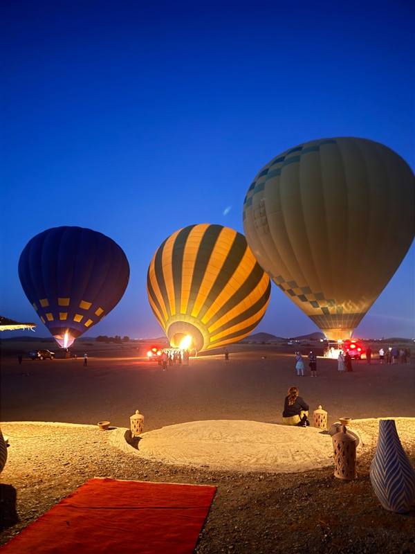Tre mongolfiere che si gonfiano di notte nel campo di decollo prima dell'alba a Marrakech