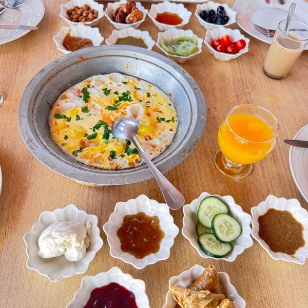 Uova, marmellate, formaggio fresco e succo d'arancia a colazione